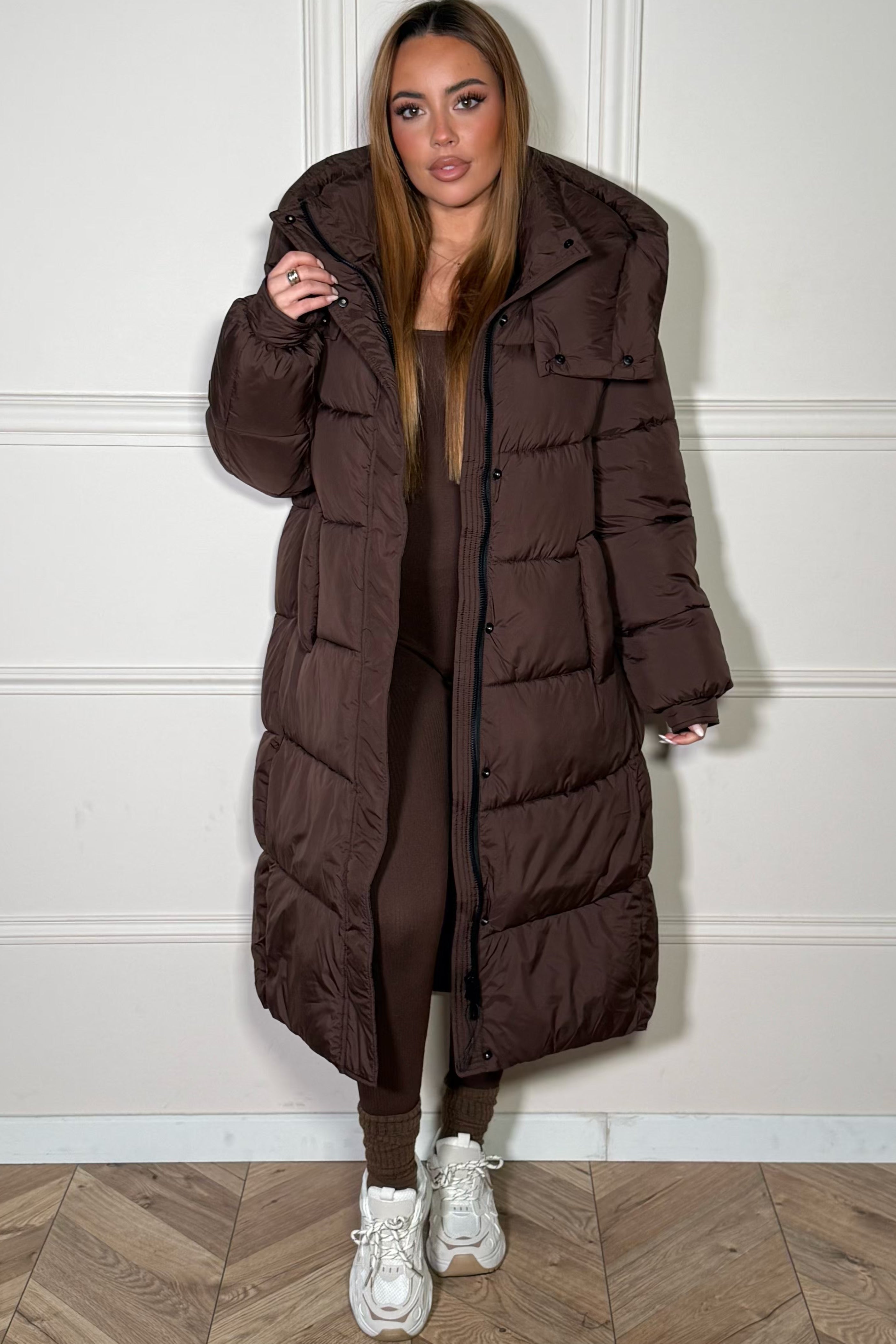 Femme portant une doudoune longue à capuche en hiver