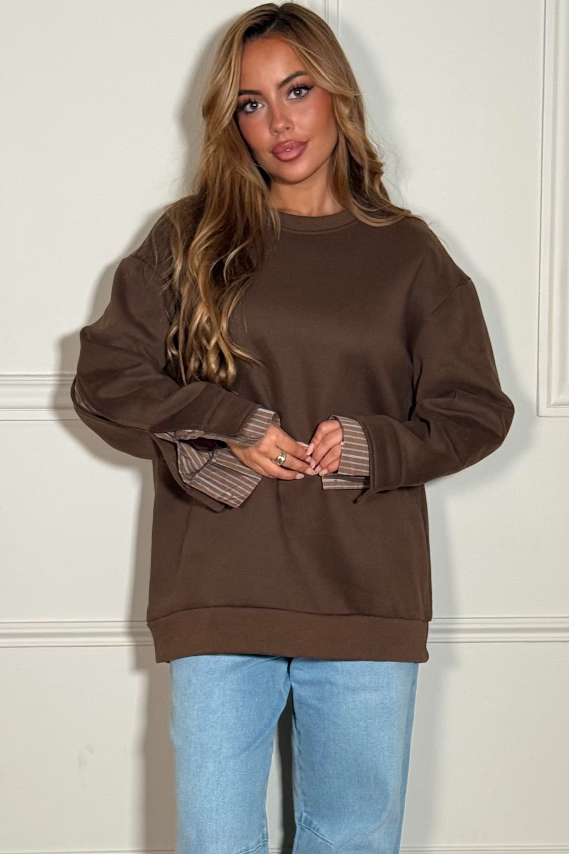 Femme portant un sweat gris à chemise intégrée blanche, style décontracté chic, vue de face