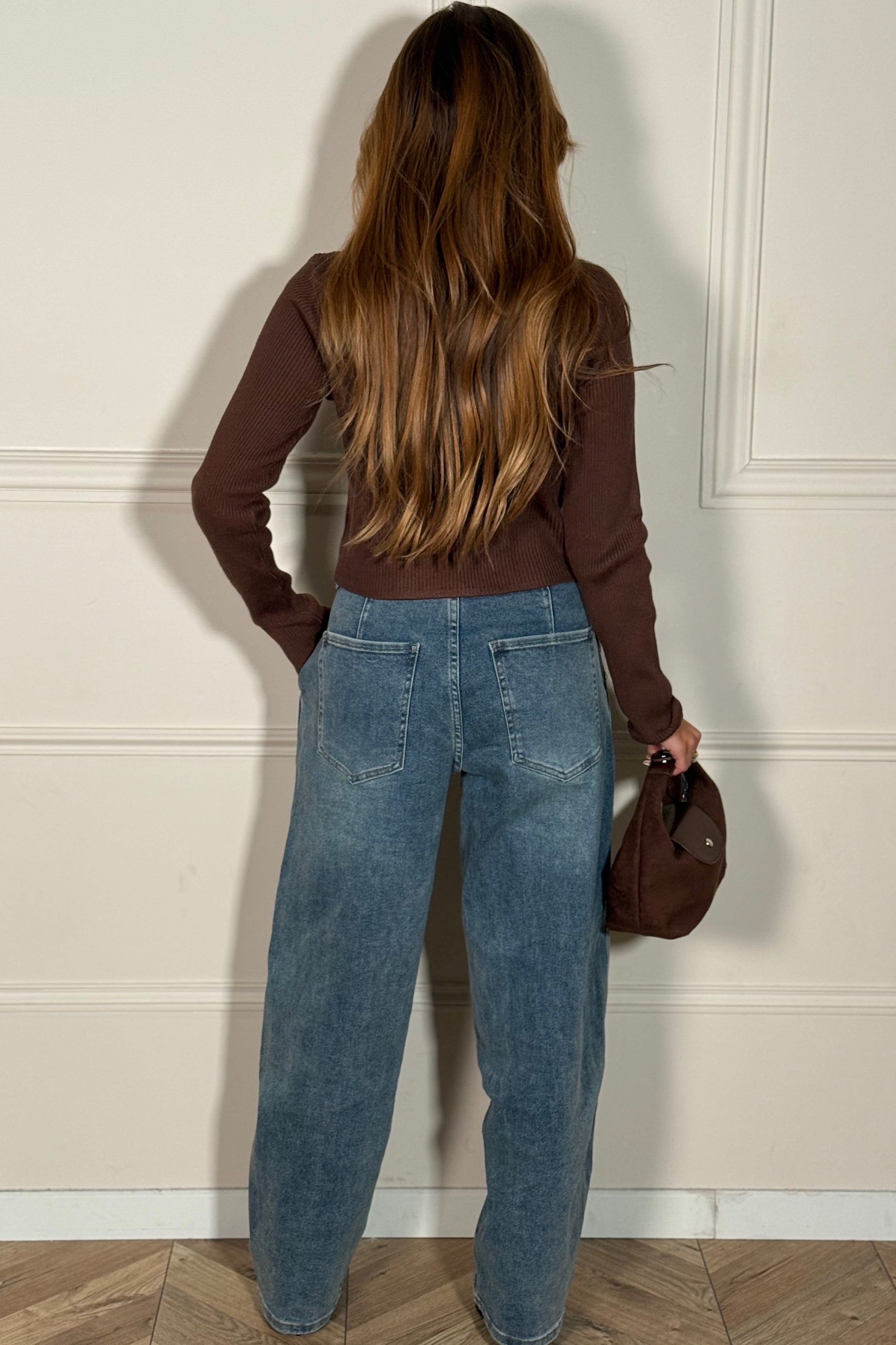 Femme portant le jeans coupe barrel avec un top blanc
