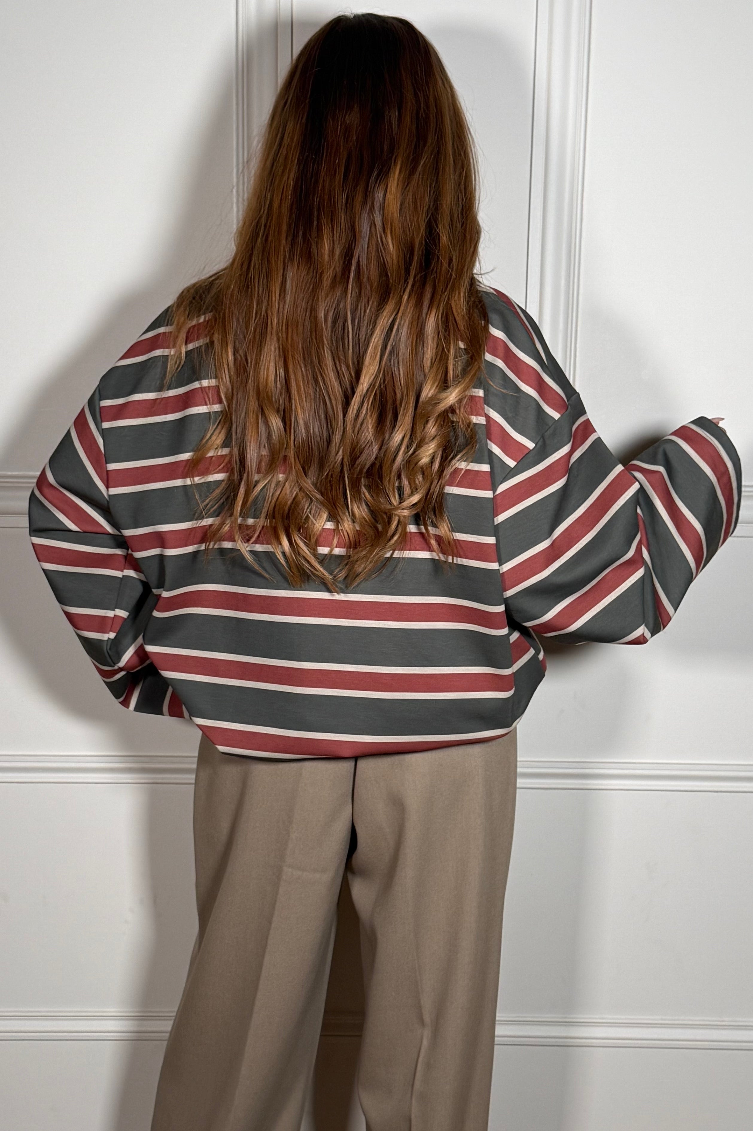 Détail finitions et manches longues du polo rayé
