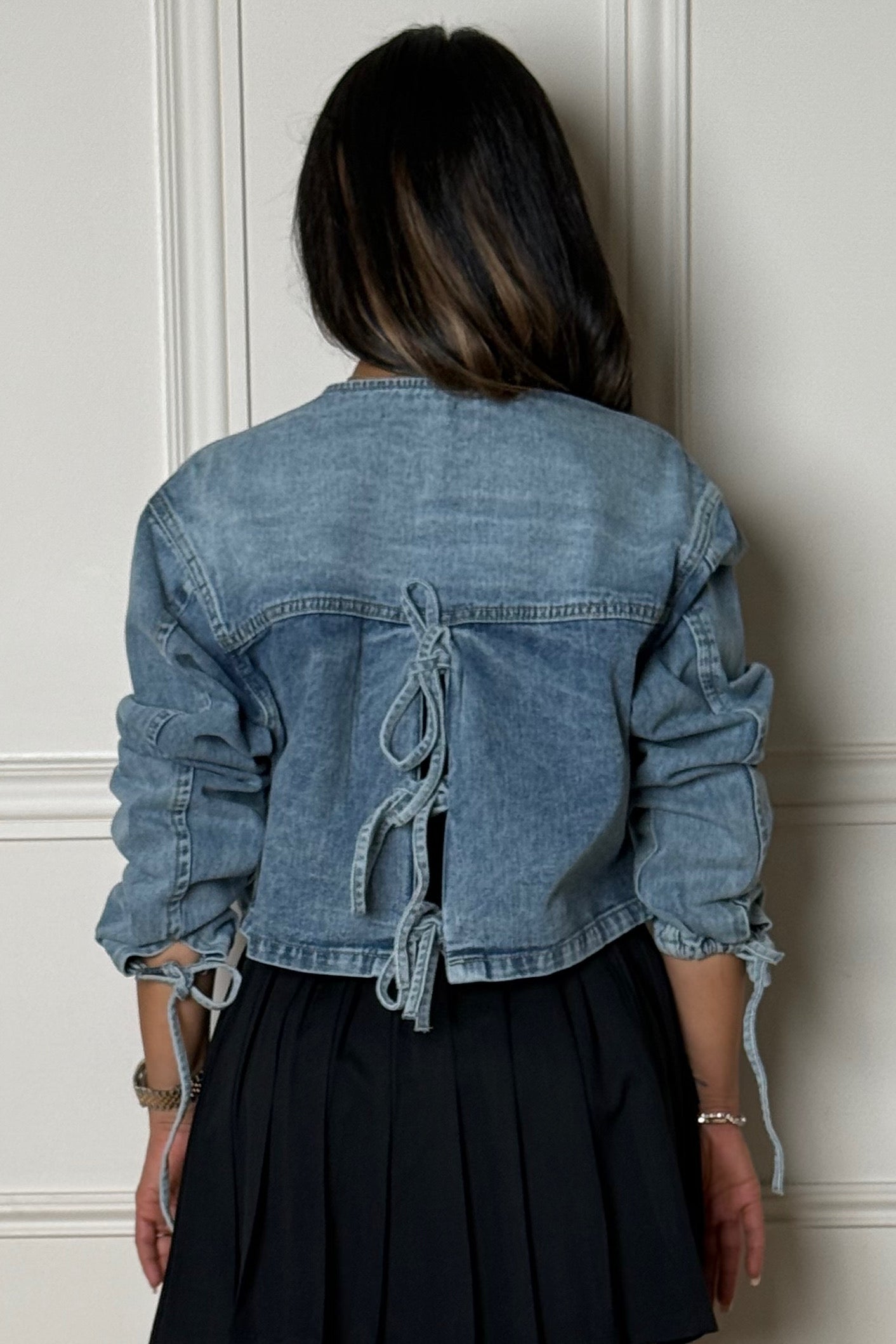 Femme portant une veste denim courte dos nœud BLOOSHOP
